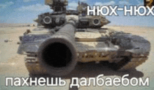 a tank is driving through a desert with a large cannon .