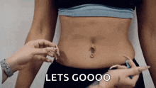 a woman 's stomach is being measured by another woman with the words `` lets goooo '' written on it .