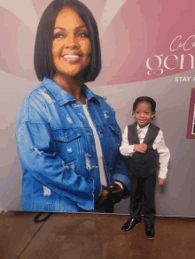 a little boy stands in front of a poster of a woman with the word generation written on it