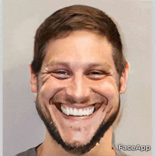 a man with a beard is smiling with a face app watermark on his face