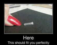 a woman 's finger with long red nails is holding a small plastic object on a black surface .