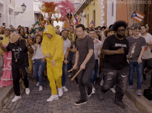 a group of people are dancing on a cobblestone street with the words tonight 's show puerto rico behind them