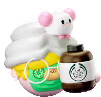 a bottle of the body shop is next to a figurine