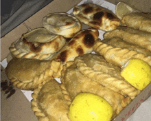 a pizza box filled with various pastries and lemons