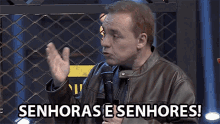 a man speaking into a microphone with the words senhoras e senhores