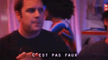 a man in a black shirt says " c est pas faux " while talking to another man