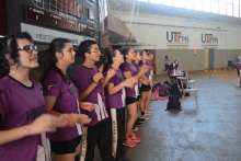 a group of girls wearing purple shirts that say ufpr are clapping