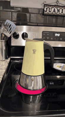 a yellow coffee pot sits on a stove next to a sign that says " juani "