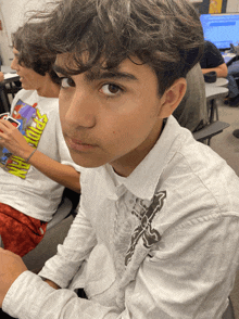 a boy wearing a white shirt that says spider-man