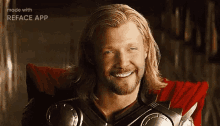 a man with long blonde hair and a beard is smiling while wearing armor .