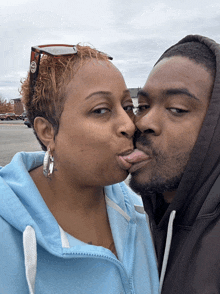 a man and woman are kissing and the woman is wearing sunglasses