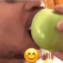 a close up of a person eating an apple with a smiley face .