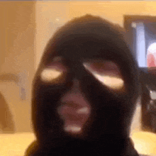 a person wearing a black ski mask with holes in it is looking at the camera .