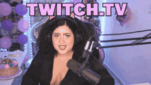 a woman wearing headphones is sitting in front of a microphone and the words twitch.tv are above her