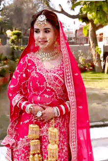 a bride in a pink and gold dress is standing in a garden