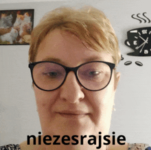 a woman wearing glasses has the word niezesrajsie on the bottom of her face