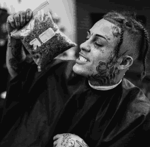 a man with a tattoo on his face is holding a bag of weed