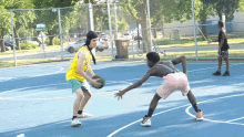 two basketball players on a court with a trash can in the background and a sign that says ' one way ' on the top