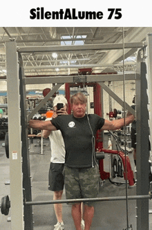 a man taking a picture of himself in a gym with the words silentalume 75 on the top