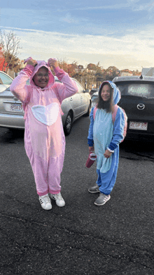 a girl in a pink unicorn costume and a girl in a blue unicorn costume