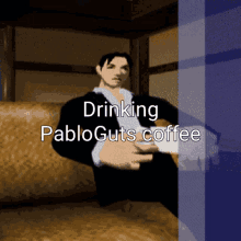 a man in a suit sits on a couch drinking coffee