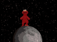 elmo from sesame street is standing on a planet in space .