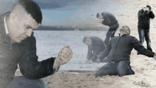 a man in a black jacket kneeling on the beach