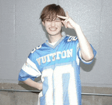 a young man wearing a blue louis vuitton football jersey