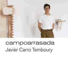 a man in a white shirt stands in front of a wall with the name campoarrasada javier carro temboury written on the bottom