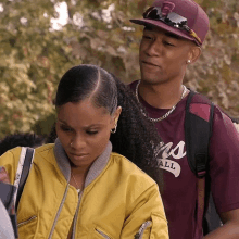 a man and a woman are standing next to each other and the woman is wearing a yellow jacket