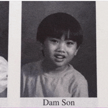 a black and white photo of a young boy with the name dam son on the bottom