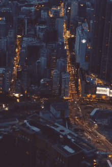 an aerial view of a city at night with a building with a purple light on the top of it