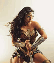 a woman dressed as wonder woman holds a sword