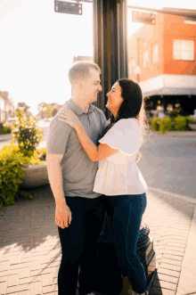 a man and a woman standing next to each other on a street