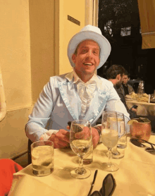 a man sitting at a table with glasses of water