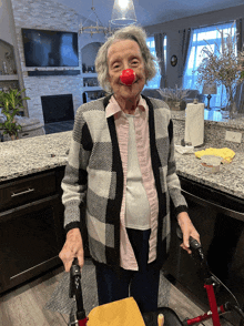 an elderly woman wearing a red nose and a plaid shirt