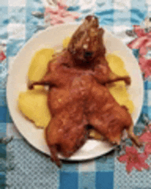 a plate of food with a roasted rat on it on a table .