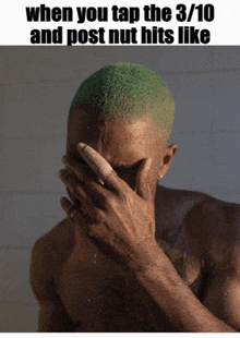 a shirtless man with green hair is covering his face with his hand