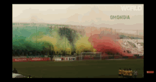 a group of soccer players stand on a field with smoke coming out of the stands in front of a mcdonald 's ad