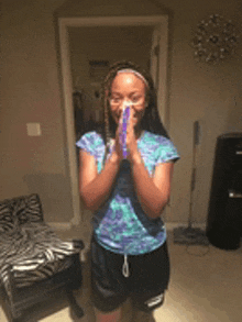 a young girl is standing in a room with her hands folded in prayer