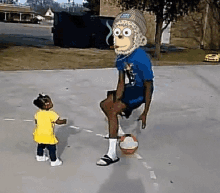 a little girl is standing next to a man wearing a monkey mask