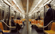 a man in a suit stands in the middle of a subway car with a sign that says " now hiring "