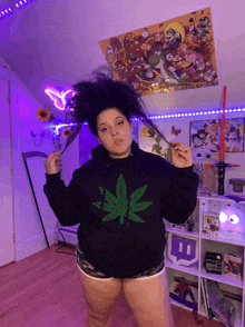 a woman in a black hoodie with a marijuana leaf on it