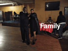 a man and a woman are dancing in a room with the word family on the bottom