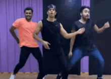 three men are dancing in a dance studio .