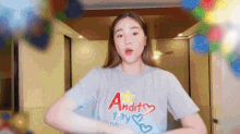 a woman wearing a blue shirt that says andit tay