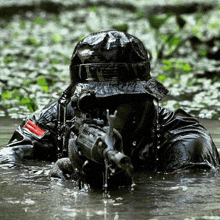 a man in a hat is holding a gun in the water with a red stripe on his arm