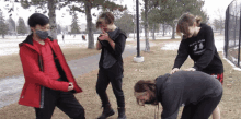 a girl wearing a black shirt that says martial arts is standing next to a boy wearing a red jacket