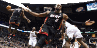 a basketball player wearing a heat jersey jumps in the air during a game