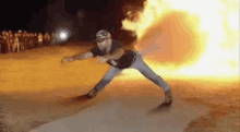 a man is standing in front of a fireball .